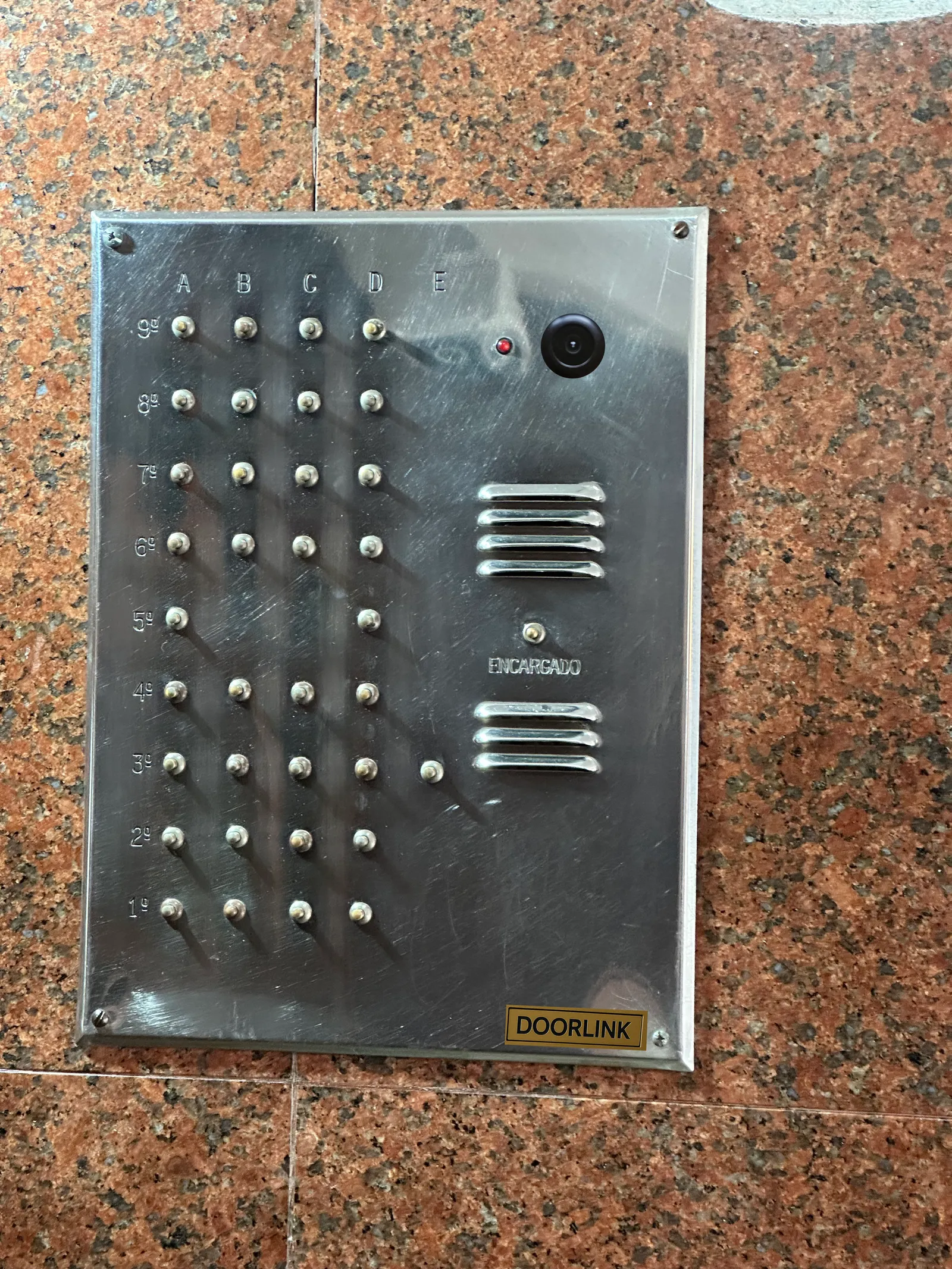 Frente de calle de un edificio con DoorLink instalado: el panel original queda intacto